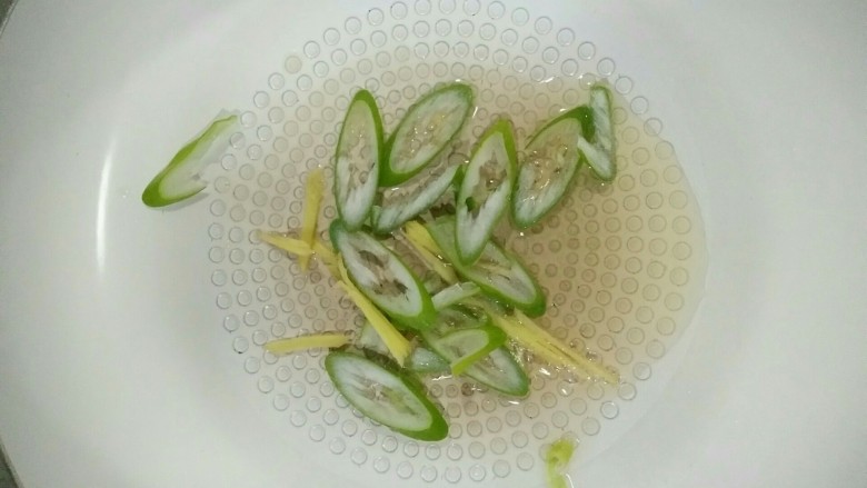 家常菠萝咕咾肉,热锅凉热，放入葱、姜，煸炒几下。
