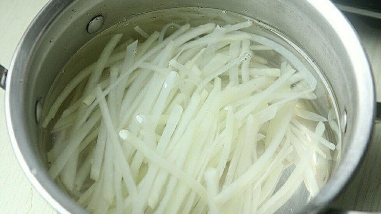 夏日小菜凉拌土豆丝,捞起土豆丝沥干水,放入凉白开内浸泡,几分钟后捞出控干水。