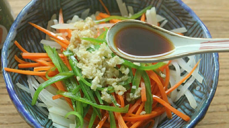 夏日小菜凉拌土豆丝,炒好的蒜蓉放入土豆丝内,倒入<a style='color:red;display:inline-block;' href='/shicai/ 692'>酱油</a> 3匙。