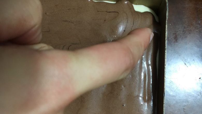 可可旋风草莓蛋糕卷,洗净手后,用食指开始从烤盘的一端连贯地划S型