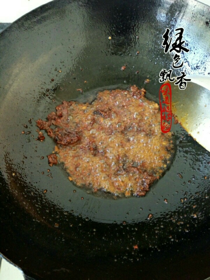 水煮肉片,放入郫县豆瓣酱和火锅底料，继续小火煸炒出红油