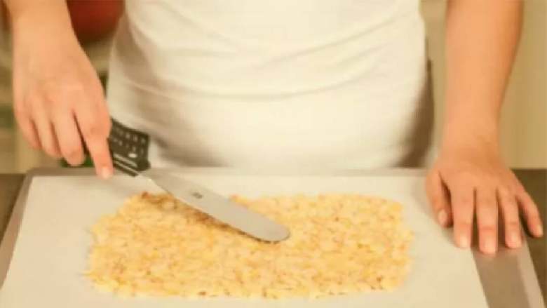 杏仁脆饼,在烤盘中铺好烘焙纸。用锅铲将混合物平铺成一个薄薄的长方形(可以你自己喜欢的任何形状)。放入烤箱,以190℃/375℉的温度烤10-15分钟