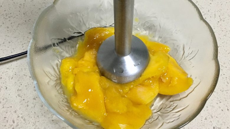 三色慕斯水果杯,冷藏的过程中我们开始做芒果慕斯层,把芒果肉用料理棒打成泥
