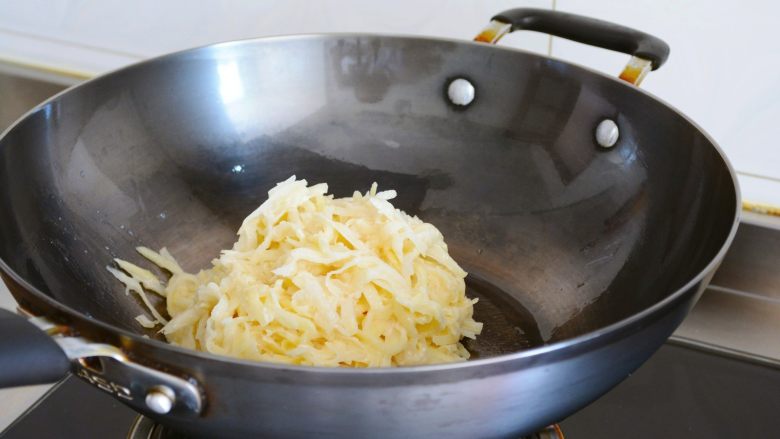 土豆烘饼】,用最少的调料还原土豆的本真~,
放入调味好的土豆丝~
把火力调成中小火~