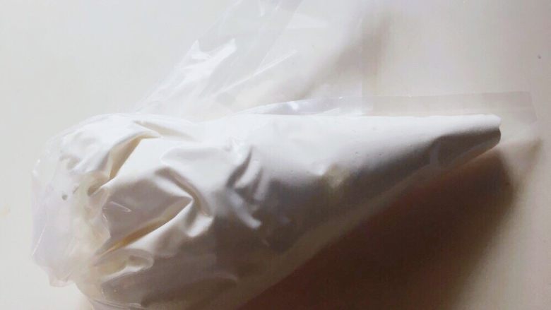鲜奶油戚风磅蛋糕,烤蛋糕期间,淡奶油加入砂糖,打至八分发,装入裱花袋中备用,裱花嘴用尖头