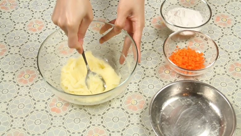 葱香田园土豆饼,蒸好的土豆倒入一个大碗里,用勺子压成土豆泥,尽量压的细腻些。