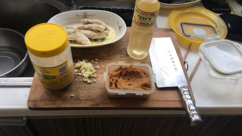 日式味增腌鸡胸肉,将煮熟的鸡胸肉沥干,切碎蒜末,这里有个小技巧,切蒜不需要剥蒜皮而是用刀背碾压,自然能去皮