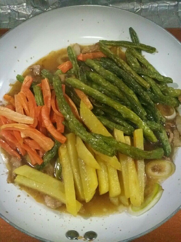 家常红烧芸豆,放入芸豆、土豆和胡萝卜,翻炒几下。放入适量温水,加入盐和白糖,翻炒一会儿,让菜入味。出锅前,放入蒜沫,翻炒几下出锅。