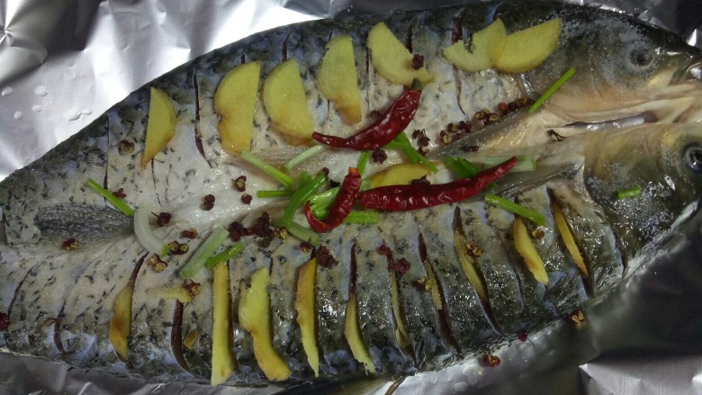 烤箱版麻辣烤鱼,腌制一小时后的<a style='color:red;display:inline-block;' href='/shicai/ 397'>草鱼</a>用厨房纸擦干多余水分,刷油,放好葱姜蒜,放入烤箱200度25分钟烤制,如果时间不够可以延长,看上色程度