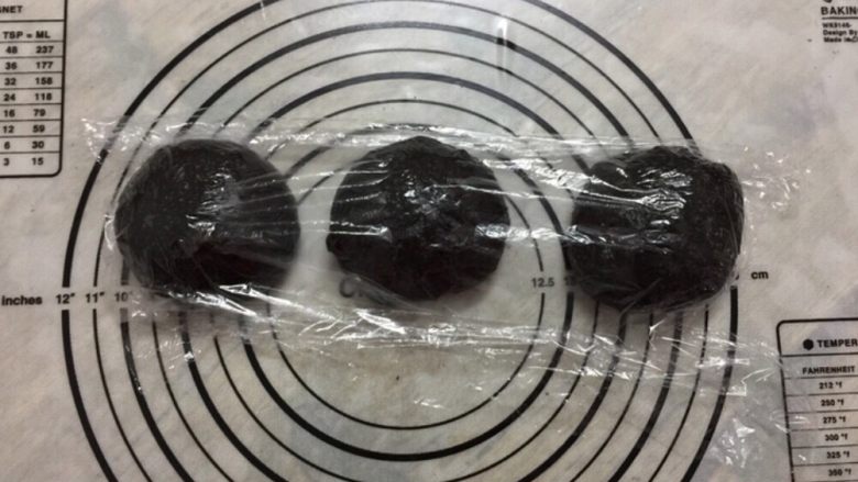 黑可可热狗包,轻揉面团排气,平均分割3个面团,分别揉圆,盖保鲜膜松弛15分钟