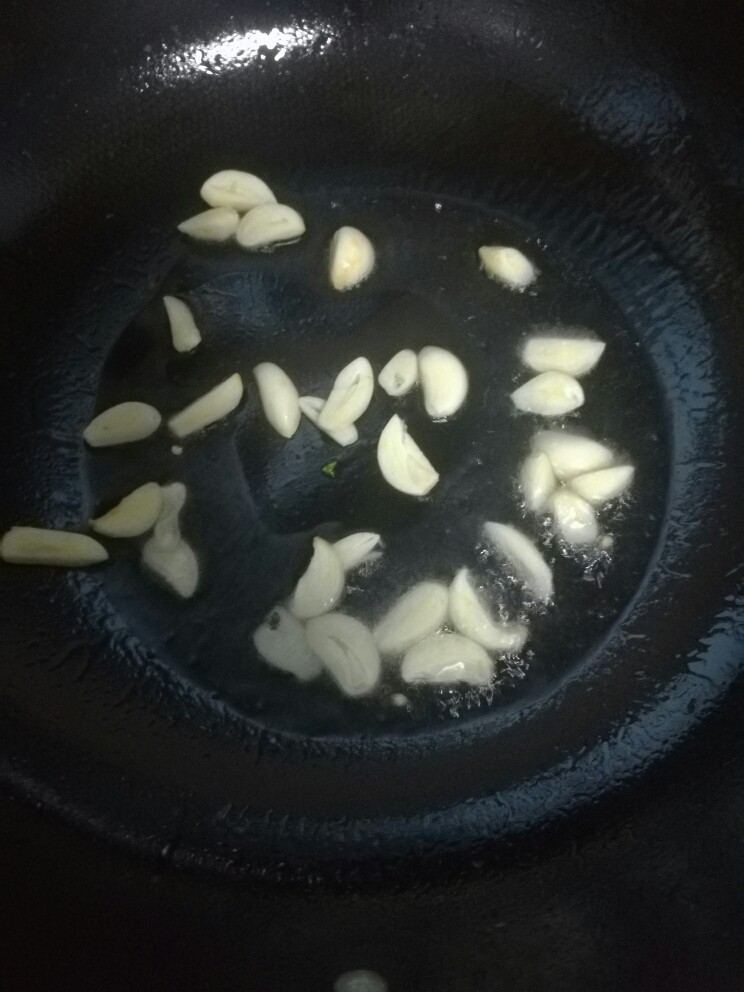 洋葱炒牛肉,坐锅热油,小火下蒜片煸香。