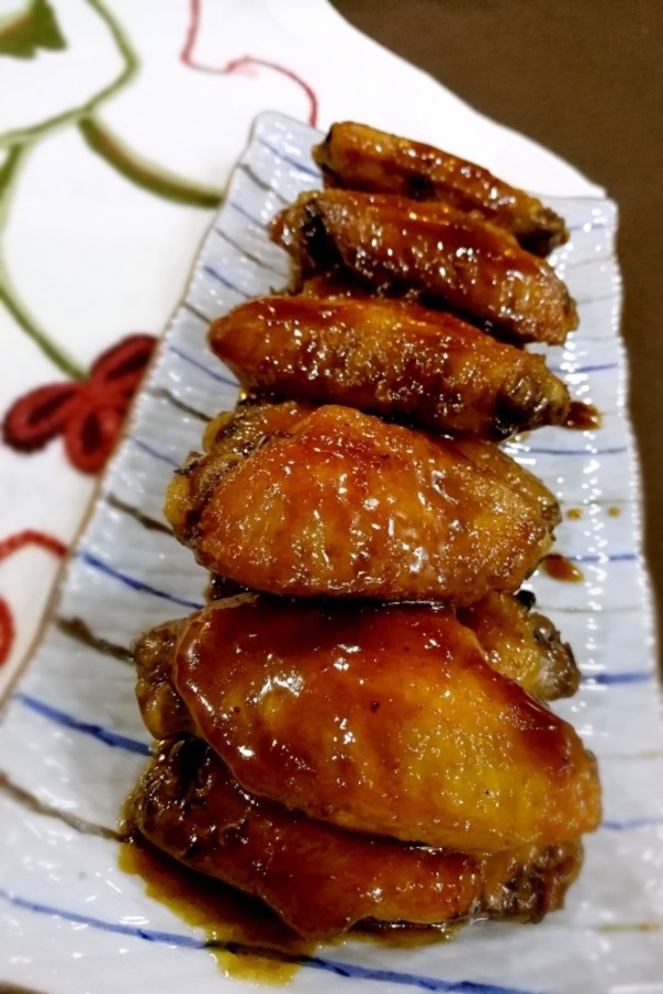 孩子最爱的可乐鸡翅,把鸡翅夹起装盘,锅里剩下的浓汁浇在鸡翅上面。