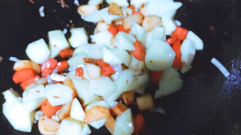 土豆香肠焖饭,倒入土豆翻炒至表面微微焦黄