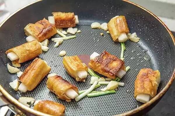 糖醋素排骨,用生抽、老抽、醋、白糖、淀粉和水调个汁儿。锅中留少许油,开中火,爆香蒜片和葱段,加入素排骨翻炒片刻。