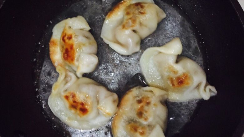 抱蛋煎饺,倒入一小碗清水,小火盖盖子煮。这步相片拍的不是很清楚,水量大概就是没过饺子边的样子