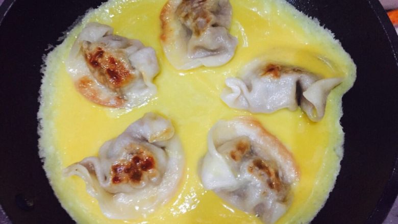 抱蛋煎饺,趁蛋液还未凝固,晃动锅子,使蛋液均匀的铺满锅底