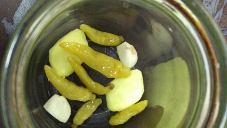 泡椒凤爪,准备一个玻璃器皿，无水无油。先铺一层姜片、蒜头和<a style='color:red;display:inline-block;' href='/shicai/ 703'>泡椒</a>。