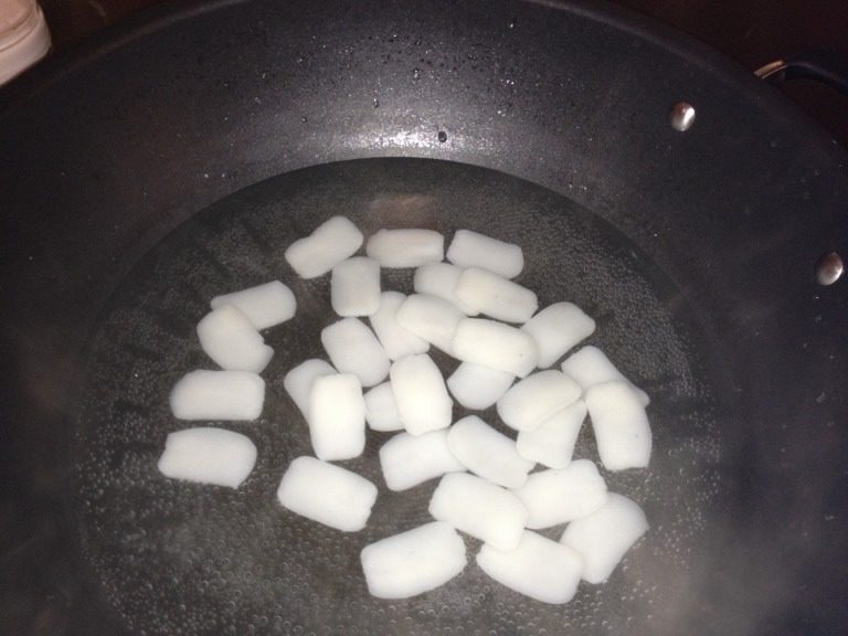 番茄炒年糕,如图把年糕分開後放入沸水中,讓它在沸騰中沸騰2分鐘。