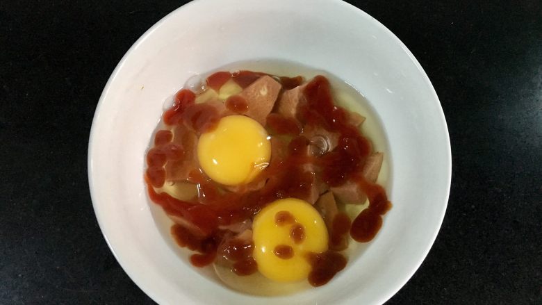火腿奶酪烘蛋,挤入两小包<a style='color:red;display:inline-block;' href='/shicai/ 753'>番茄沙司</a>,如果没有小包的,那就根据感觉挤吧!多点少点都无所谓