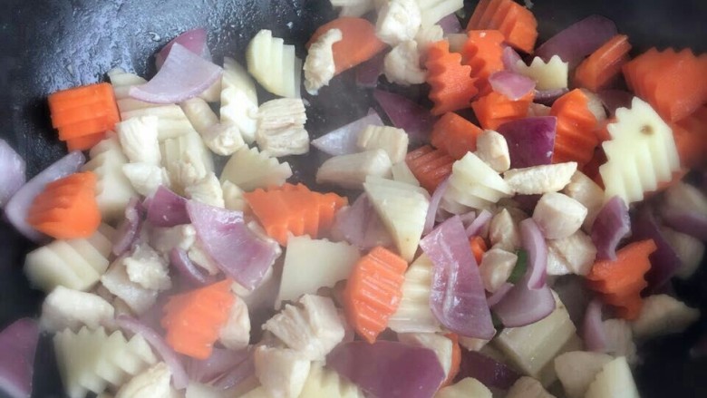 家常咖喱鸡肉,继续加入胡萝卜，土豆块翻炒均匀