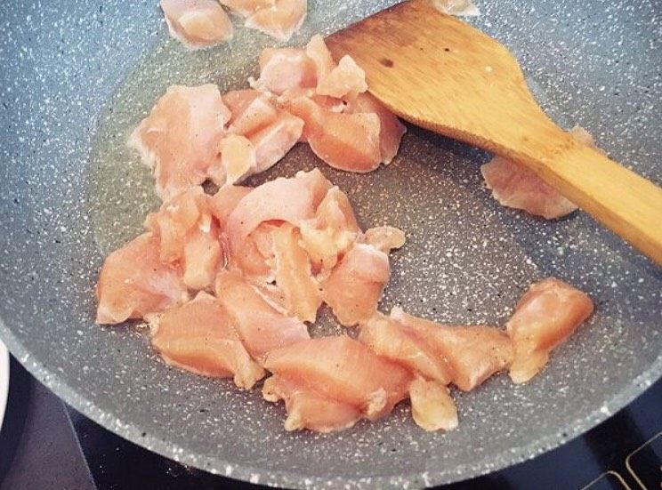 菠萝鸡丁,锅里加橄榄油,放入鸡丁煎至变白。