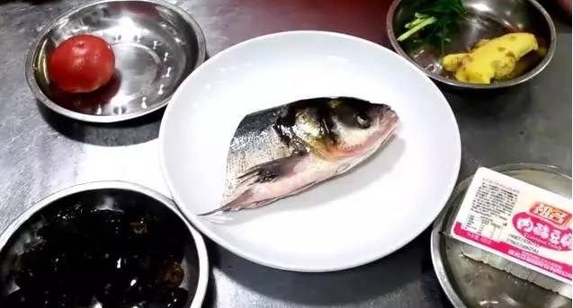 番茄鱼头豆腐汤,将<a style='color:red;display:inline-block;' href='/shicai/ 336'>鱼头</a>去腮洗净用菜刀将<a style='color:red;display:inline-block;' href='/shicai/ 336'>鱼头</a>切成两半但不要完全切开，将<a style='color:red;display:inline-block;' href='/shicai/ 465'>豆腐</a>切成均匀的方块，<a style='color:red;display:inline-block;' href='/shicai/ 59'>番茄</a>分成小块，将葱打结姜切成片，如是买的干木耳，提前使用温水来浸泡。