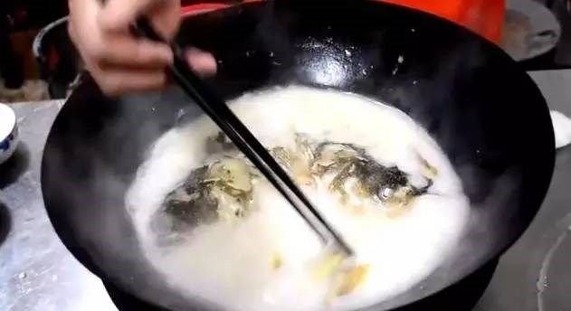番茄鱼头豆腐汤,5分钟后开盖,这个时候我们可以看到鱼头汤的浓度已经非常高了,并且汤泛着奶白色,这个时候我们把葱结和姜片使用筷子夹出。