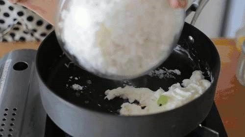 瑶柱蛋白蔬菜炒饭,这时倒入米饭和炒好的蔬菜和瑶柱一起炒匀并炒香,放少许的盐和鸡粉,出锅时加入葱花和几滴生抽翻炒几下即可装盘。