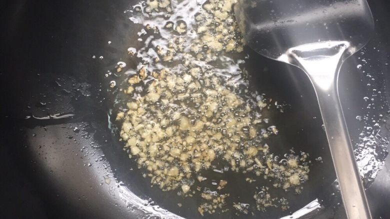 避风塘炒虾,锅里剩一点底油,放入蒜末小火炒香