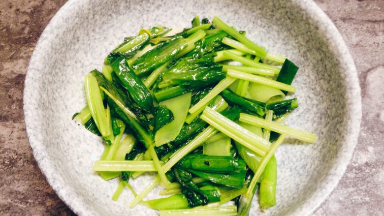 香辣水煮牛肉,炒锅内加入色拉油约15g,中火烧至约四成热,下入备好的蔬菜,撒入少许盐,炒至断生后出锅垫入碗底。