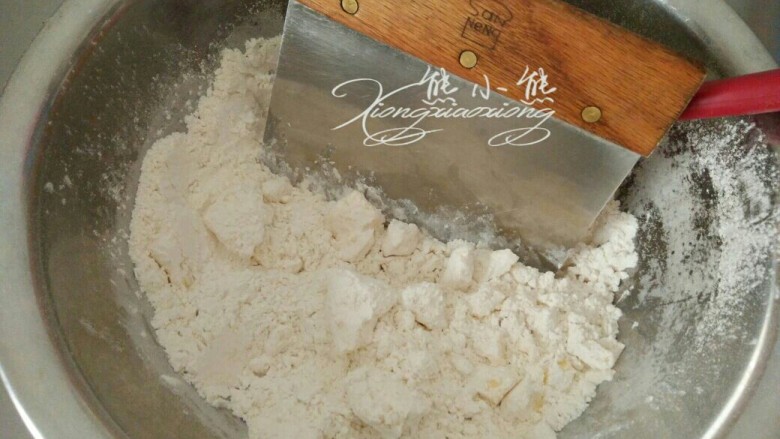 心心相映核桃派,取出冰镇好的面粉黄油用刮板切拌混合，至整体成为细颗粒状。黄油如果融化就无法混拌了，所以动作要快。