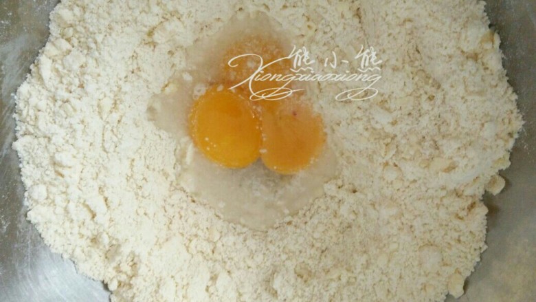 心心相映核桃派,倒入<a style='color:red;display:inline-block;' href='/shicai/ 15'>蛋黄</a>、盐、冷水,切拌混合低粉与蛋液,全部均匀混合,放到硅胶垫上。