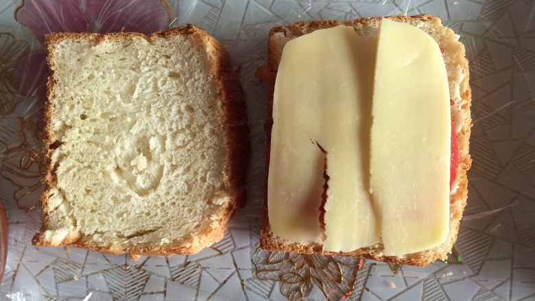 吐司的三明治吃法,一层<a style='color:red;display:inline-block;' href='/shicai/ 86198'>番茄片</a>，一层<a style='color:red;display:inline-block;' href='/shicai/ 62159'>芝士片</a>。