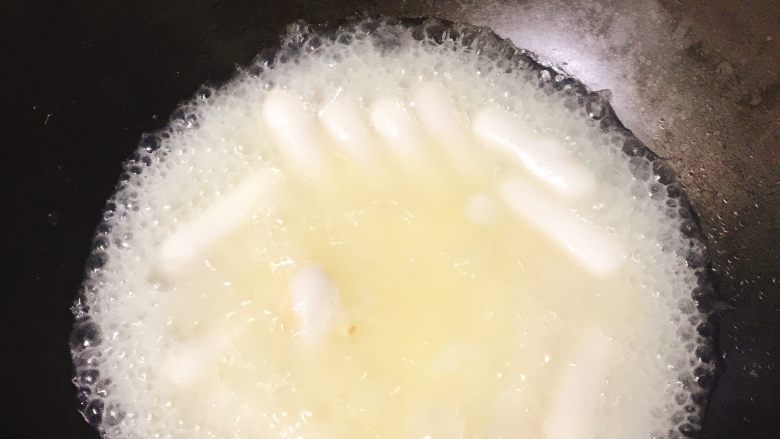 葱花蛋散夹心年糕,锅里倒入开水，倒入年糕多煮几下，夹心年糕有糯米成分所以多煮一会儿，大概在锅里的水成黄色，就表示年糕里的夹心外流，用筷子夹一夹感受年糕的软度，可以就起锅