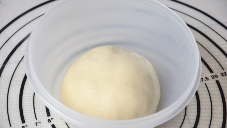 淡奶油椰蓉面包卷,将揉好的面团放入烤箱中进行第一次发酵,在面团上盖一层保鲜膜,烤箱里放一碗温水,30度1小时(冬天时间根据面团发酵状态适当延长时间,而夏天30
