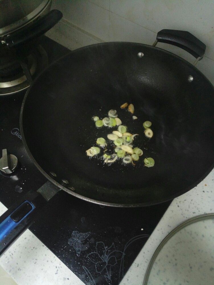 蛤蜊烩饼,烧热油,加入葱,蒜爆锅