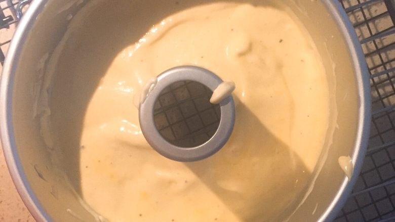 百香果戚风,倒入中空模具中，用刮刀整形平整。手握模具两侧，两个大拇指按住烟囱顶部，清磕几次