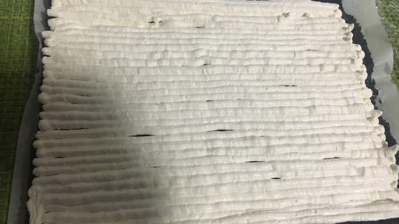 抹茶奶冻竹炭卷,两侧留些空隙,其余的全部均匀的挤满奶油
