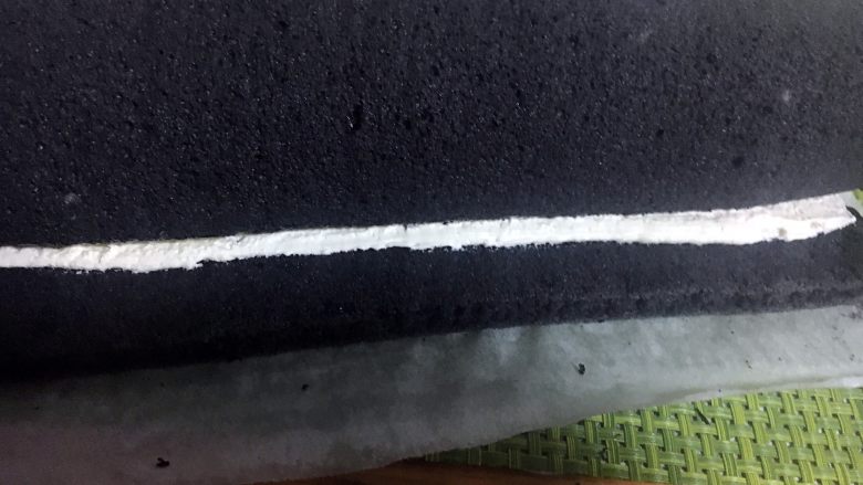 抹茶奶冻竹炭卷,卷满一圈后,切去多余的蛋糕体