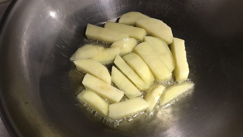 豆角土豆焖面,锅里放适量油，火不要太大，土豆放入锅中煎一会儿翻身
