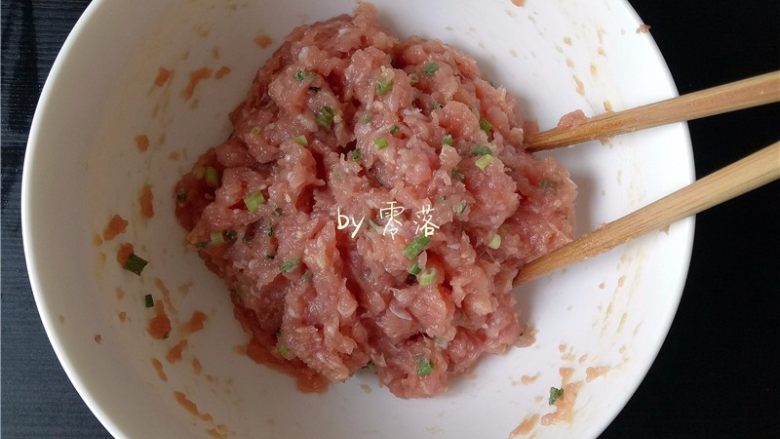 四川抄手,肉馅用筷子往一个方向搅拌至肉馅起胶;再调入葱末,再搅拌均匀;
