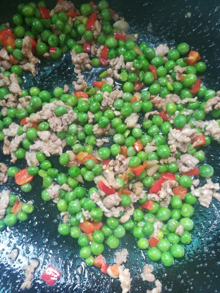酸菜肉沫炒豌豆,下肉丁炒散,撒适量盐,味道与肉一起炒匀。