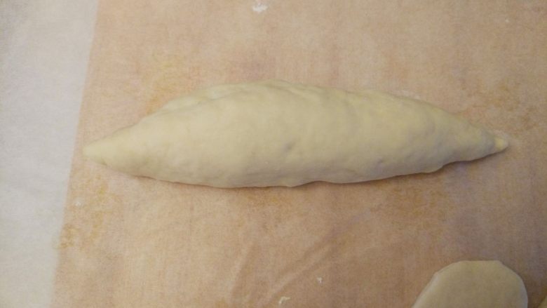 龙虾面包,制作主体:取大小合适的一块儿,揉成两头稍尖的橄榄形