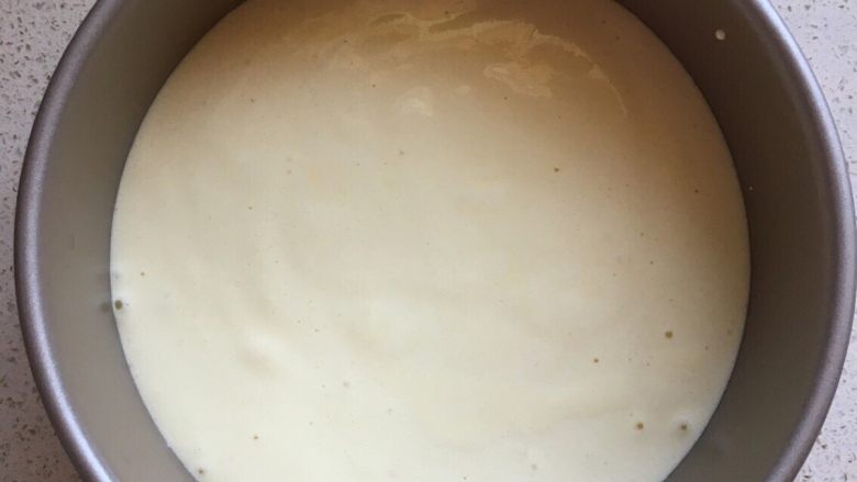 零失败草莓奶油裸蛋糕6寸,把面糊倒进6寸活模中（因为是活底，一定要用锡纸把底部包裹好，防止面糊流出来），把装好面糊得模具拿起离台面有三十公分，然后向下震两下，为的是把面糊中的大气泡震出来，这样烤出来的蛋糕就不会有大窟窿眼了