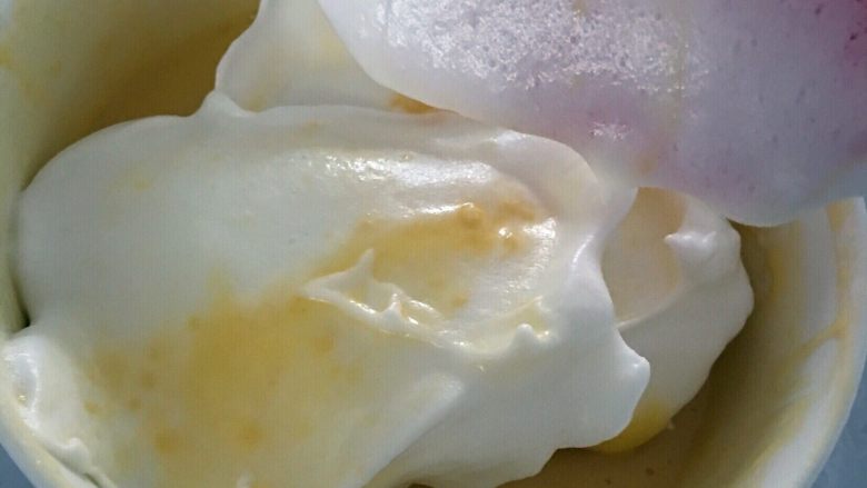 炫彩(三色)戚风蛋糕,三分之一的蛋白倒入蛋黄液中,搅拌均匀。