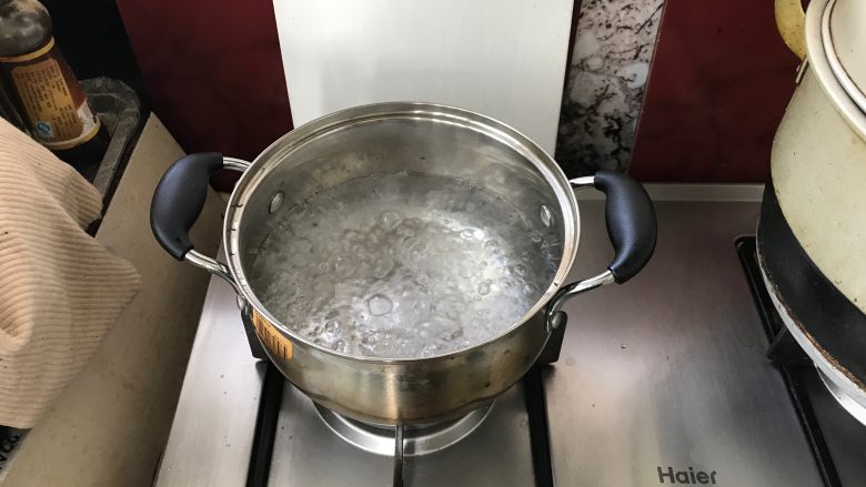 家庭煲仔饭,锅中倒入清水煮沸。
