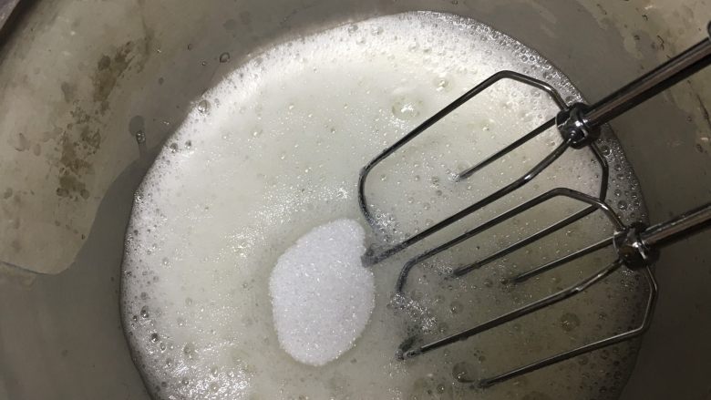 宝宝零食~奶溶豆,蛋清用打蛋器打出泡沫状态,第一次加入砂糖。