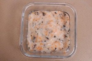 蒸鱼糕-宝宝辅食,倒入搅拌均匀的鱼泥陷,用勺子或者刮刀抹平,轻轻在桌子上震两下,震出气泡。