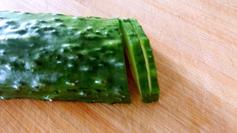 喜欢吃黄瓜的人注意了，这种做法让您吃得与众不同,用锋利的小刀把黄瓜均匀的切二片，注意不能切断。