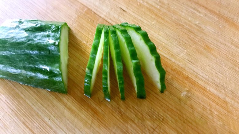 喜欢吃黄瓜的人注意了，这种做法让您吃得与众不同,用锋利的小刀把黄瓜均匀的切五片，注意前四片不能切断，第五刀切断。